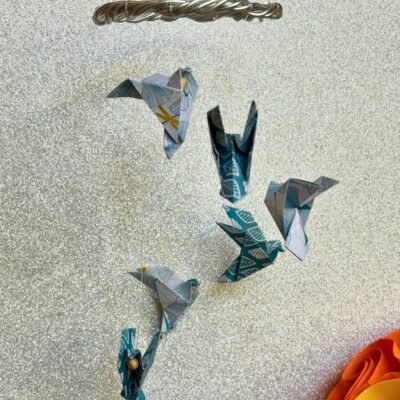 Les mini-mobiles sont composés d'un cercle en fil de fer sur lequel pendent six fil de nylon avec des colombes en origami en alternant les couleurs blanc et bleu.