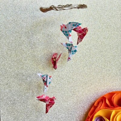 Les mini-mobiles sont composés d'un cercle en fil de fer sur lequel pendent six fil de nylon avec des colombes en origami en alternant les couleurs blanc et rouge.