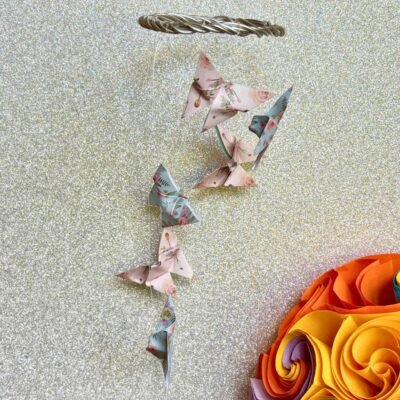 Les mini-mobiles sont composés d'un cercle en fil de fer sur lequel pendent six fil de nylon avec des papillons en origami en alternant les couleurs bleu et rose.