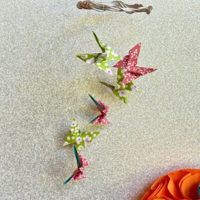 Les mini-mobiles sont composés d'un cercle en fil de fer sur lequel pendent six fil de nylon avec des papillons en origami en alternant les couleurs vert et rose.