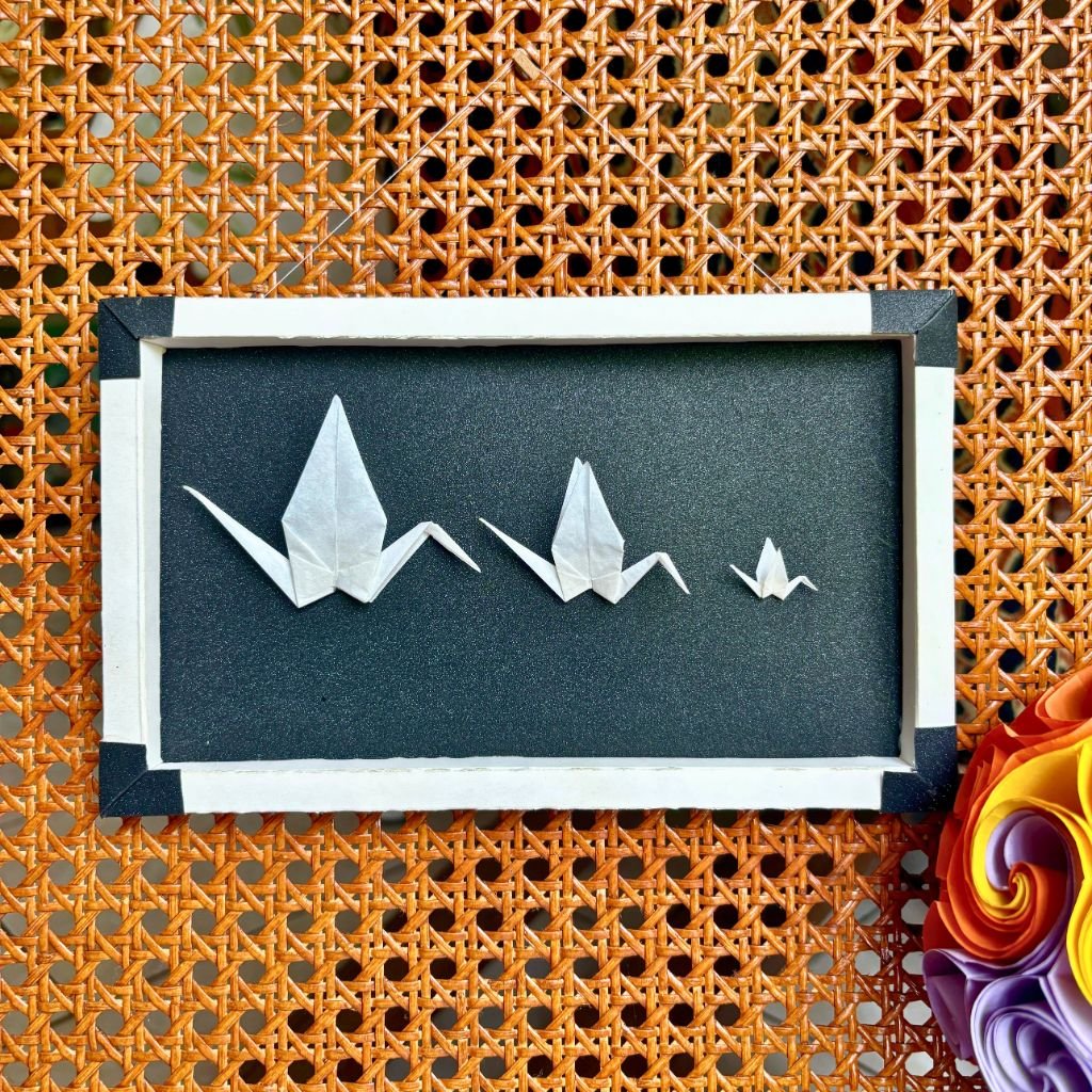 Un cadre rectangle plié à la main, de couleur blanc et noir brillant. A l