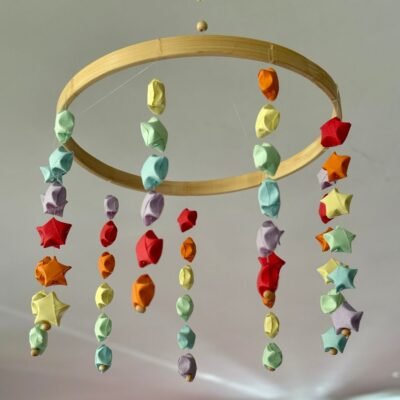 Un mobile avec un cercle en bambou d'environs 15cm, il est composé de neuf descentes de fil de nylon sur lesquelles sont disposées six petites étoiles en origami. Les couleurs des étoiles sont les suivantes : rouge, orange, jaune, vert, bleu, mauve.