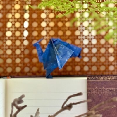 Un marque page en forme de dragon. Il se glisse entre les pages et le dragon se pose sur le haut du livre. Il est de couleur bleu/violet avec un style galaxie.